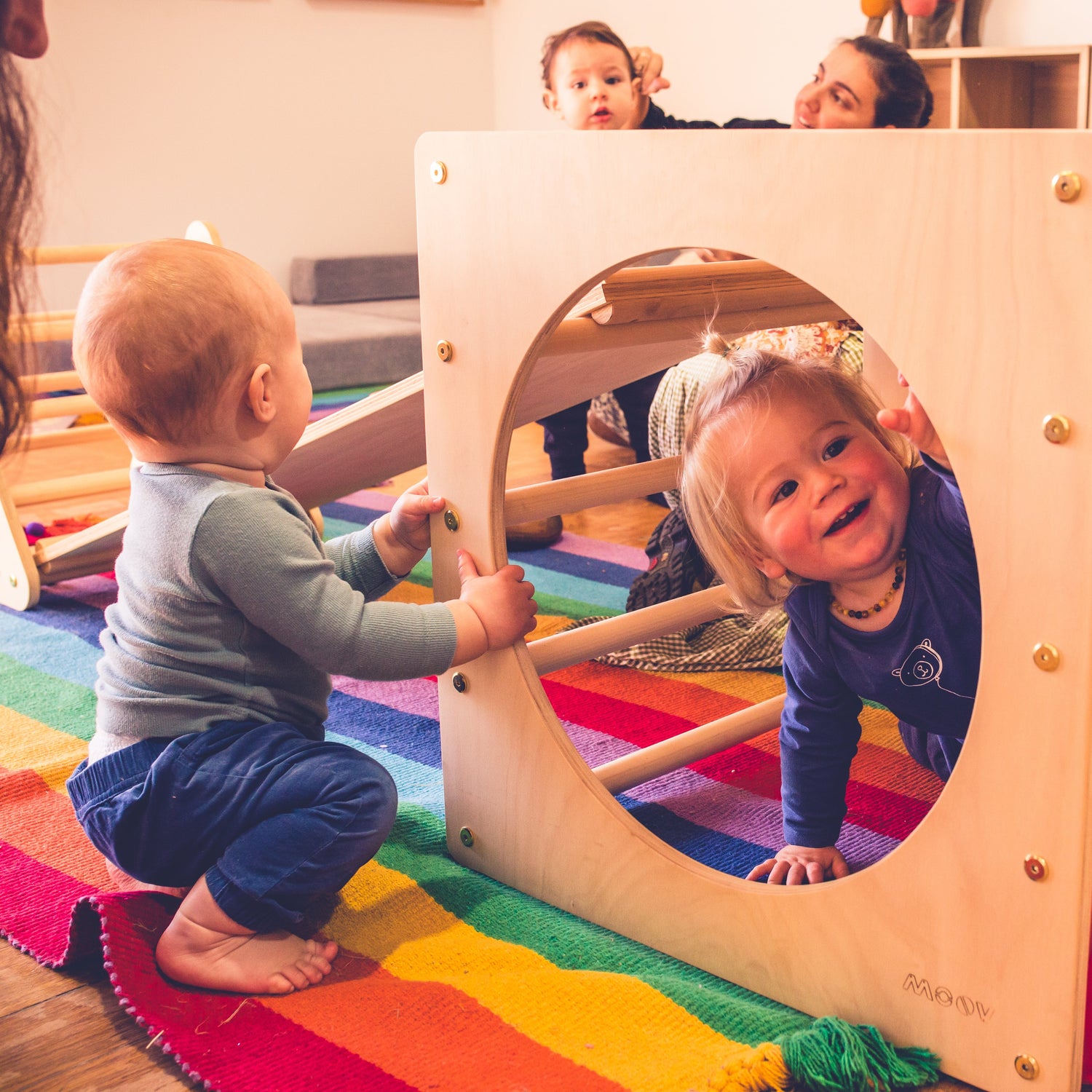 Children playing with a colorful play structure in a nursery